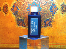 photo of 25ml sapphire blue bottle with silver lid and silver engraved plate of emerald saphir