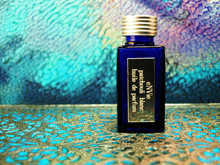 photo of 25ml sapphire blue bottle with silver lid and silver engraved plate of patchouli blanc